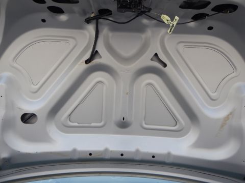 2002 Mercury Grand Marquis - Underside of a car hood showing stamped bracing and a wiring harness attached.