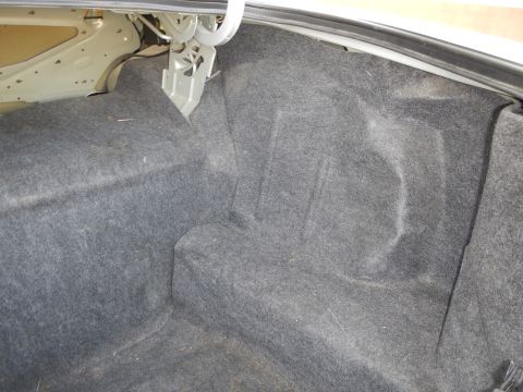 2002 Mercury Grand Marquis - The interior of a car's trunk is shown, grey carpeting and exposed metal bracing.