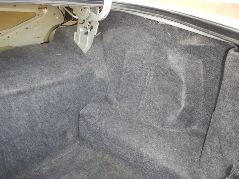 Trunk interior with grey carpet and metal bracing
