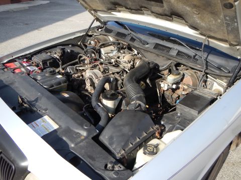 2002 Mercury Grand Marquis - The engine bay of a 2002 Mercury Grand Marquis is shown with the hood open, revealing the motor and various parts.