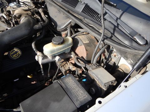 2002 Mercury Grand Marquis - Close-up view of the engine bay, showing the brake fluid reservoir, fuse box, and various engine components.