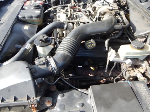 2002 Mercury Grand Marquis - Close-up view of a vehicle's engine bay, showing various mechanical parts and hoses.