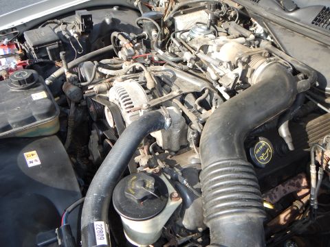2002 Mercury Grand Marquis - The engine bay of a 2002 Mercury Grand Marquis reveals its V8 engine components, including the alternator and air intake.