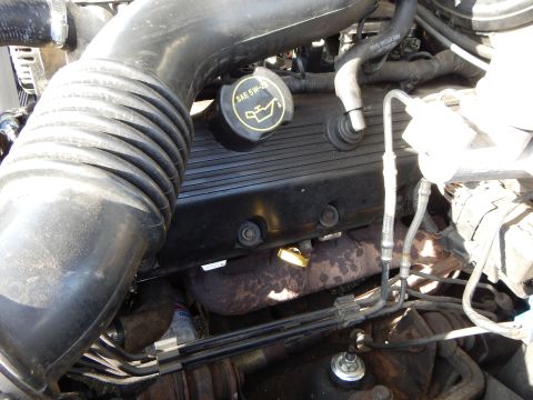 2002 Mercury Grand Marquis - Close-up view of the engine bay in a 2002 Mercury Grand Marquis, showing the oil cap and exhaust manifold.