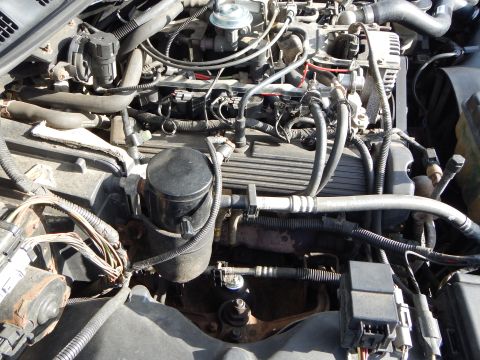 2002 Mercury Grand Marquis - Close-up view of a vehicle's engine bay, showing various hoses, wires, and engine components.