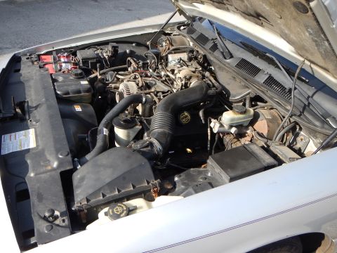 2002 Mercury Grand Marquis - The engine bay of a silver car is shown with the hood open, revealing the engine components.