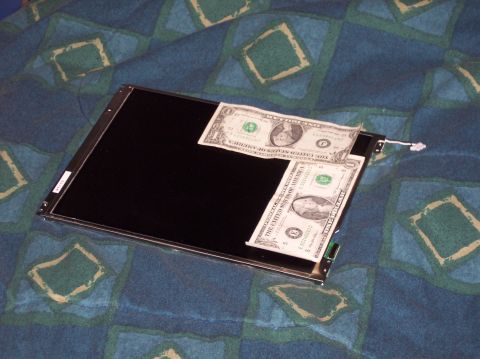 1990 Ford Bronco - A car stereo screen is shown with two dollar bills placed on it, resting on a patterned blanket.