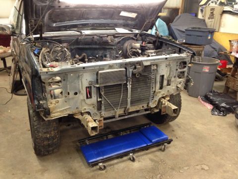 1993 Ford Bronco - Front end of a 1993 Ford Bronco disassembled for repair or modification in a garage.
