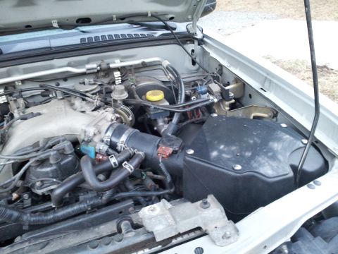 2003 Nissan Frontier - Close-up view of the engine compartment, showing various mechanical components and wiring.