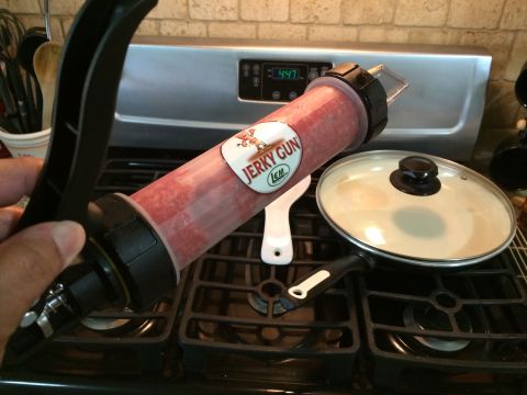 1968 Ford Mustang - A jerky gun is loaded with meat and positioned over a stovetop, next to a covered frying pan.