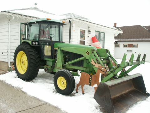 1966 Ford Bronco - Green John Deere tractor with front loader, decorated with reindeer and a Santa hat, sits in the snow.