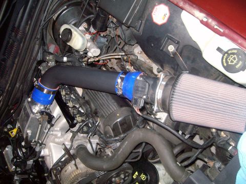 2004 Ford Crown Victoria - Close-up of an engine bay showing an aftermarket air intake system installed.