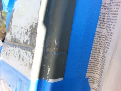 1992 Ford Bronco - Close-up of automotive body panel repair work, showing a seam and masking tape.