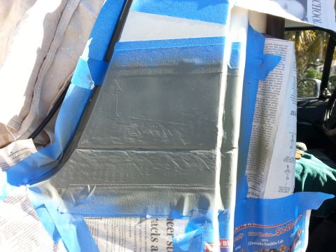 1992 Ford Bronco - Body panel masked for repair work, with newspaper protecting surrounding areas.