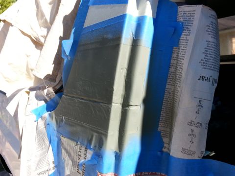 1992 Ford Bronco - A car part is covered in tape and newspaper, ready for a paint job.