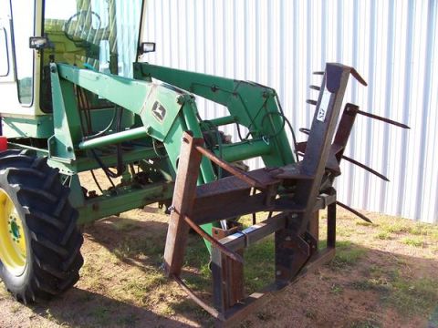 1963 Hummer H3 - A green tractor equipped with a front loader and hay forks is shown from the side.