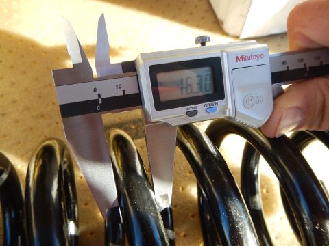 2003 Ford Crown Victoria - Mitutoyo digital caliper reading 16.30 is held over a black coil spring resting on a perforated tan pad.