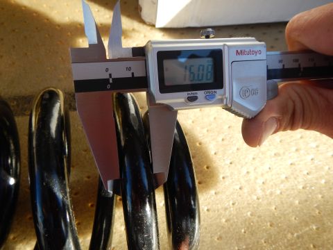 2003 Ford Crown Victoria - Mitutoyo digital caliper displaying 15.08 measures the wire of a black coil spring lying on a perforated tan pad.