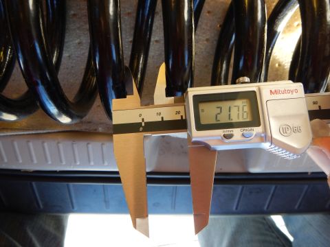 2003 Ford Crown Victoria - Mitutoyo digital caliper displaying 21.76 measures the coil spacing of a black coil spring over a bed liner.