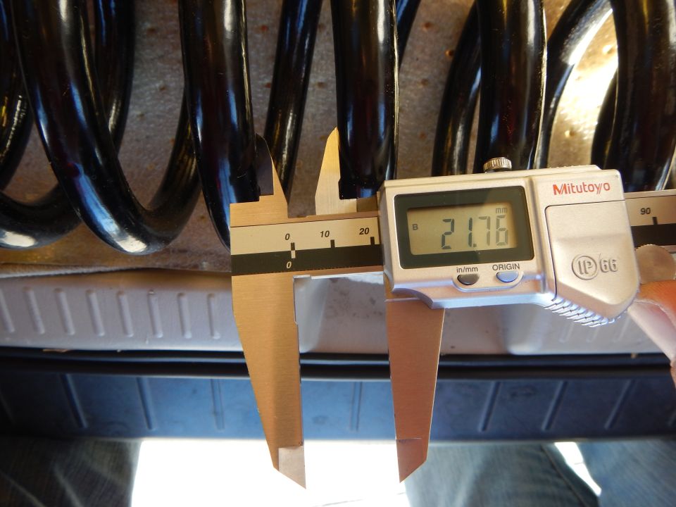 Mitutoyo digital caliper reading 21.76 measuring black coil spring