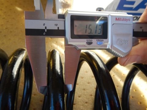 2003 Ford Crown Victoria - Mitutoyo digital caliper showing 15.13 measures the wire of a black coil spring on a perforated tan pad.