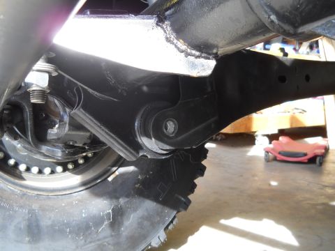 1992 Ford Bronco - Detail of a vehicle's suspension system, focusing on the linkage and tire.