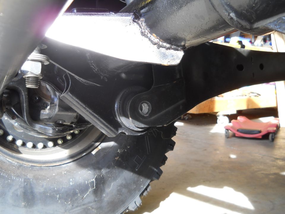 Close-up of vehicle suspension linkage and tire