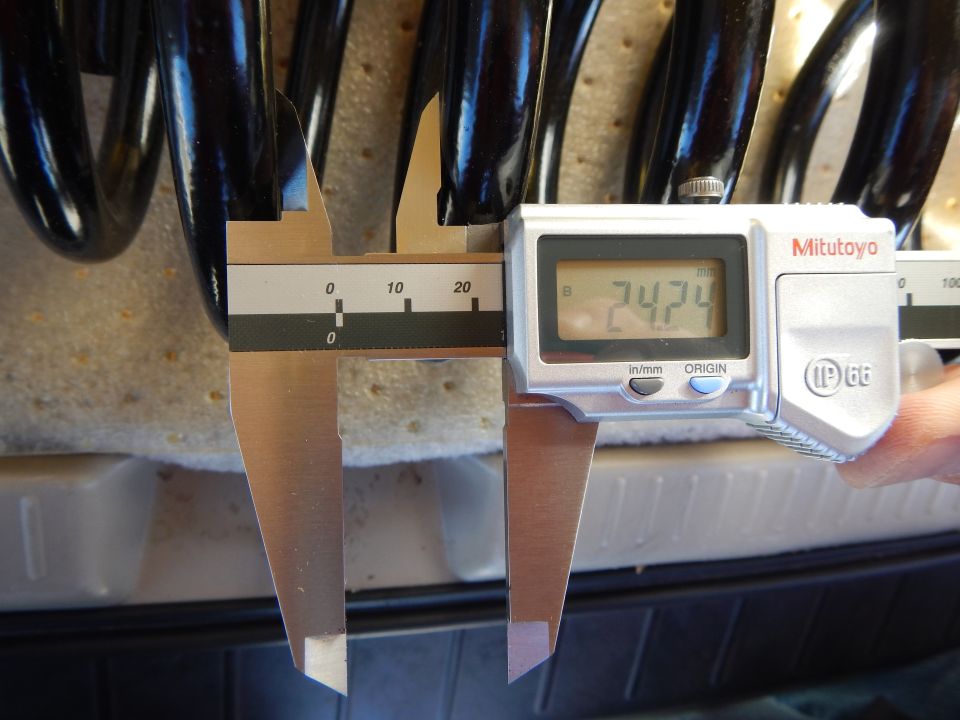 Mitutoyo digital caliper reading 74.74 measuring black coil spring