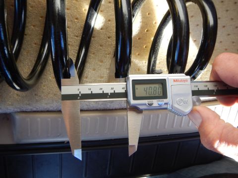2003 Ford Crown Victoria - Mitutoyo digital caliper displaying 40.80 measures the coil spacing of a black coil spring on a tan pad.