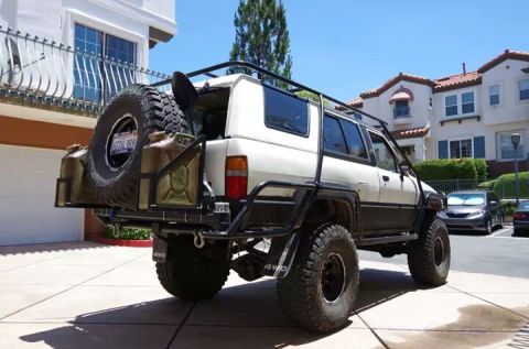 1985 Toyota 4Runner - This modified 1985 Toyota 4Runner features a custom rear bumper with a spare tire and fuel cans, plus a roof rack and large off-road tires.