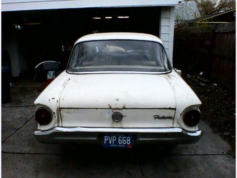 1960 Ford Falcon - The rear of a white 1960 Ford Falcon shows its taillights, chrome bumper, and a license plate.