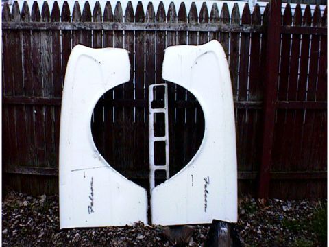 1960 Ford Falcon - Two white fenders, each with the script 'Falcon' written on them, are displayed against a wooden fence.