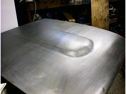 1960 Ford Falcon - A car hood with a prominent raised scoop is shown, likely undergoing restoration or modification.