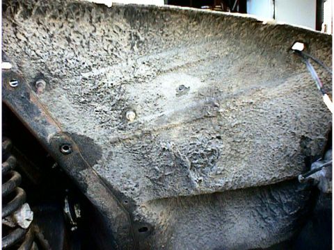 1960 Ford Falcon - The undercarriage of a vehicle shows significant corrosion and accumulated dirt, obscuring any specific model details.