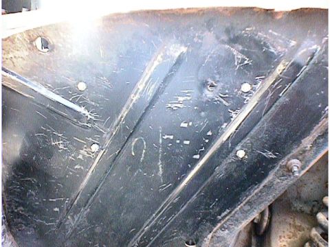 1960 Ford Falcon - Close-up of a worn metal panel, possibly from a vehicle's undercarriage, showing signs of damage.