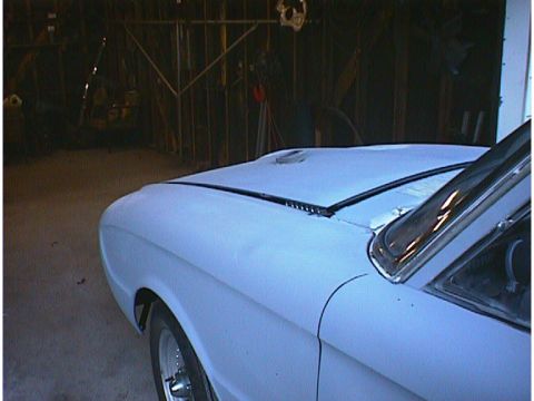 1960 Ford Falcon - A light blue 1960 Ford Falcon is partially visible in a garage, showing its front passenger side.