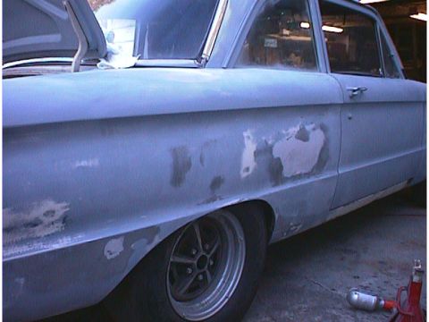 1960 Ford Falcon - Side view of a 1960 Ford Falcon undergoing bodywork, showing primer and filler.