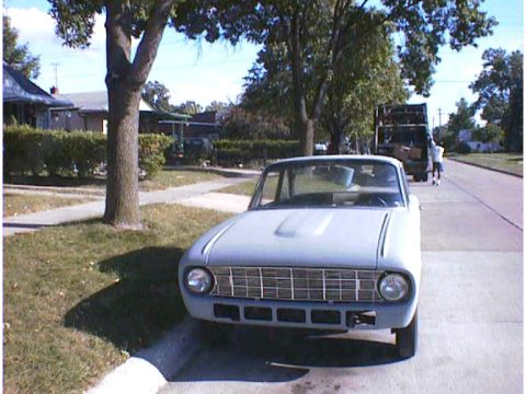 1960 Ford Falcon - A 1960 Ford Falcon is parked curbside on a sunny day, with a tree and houses in the background.