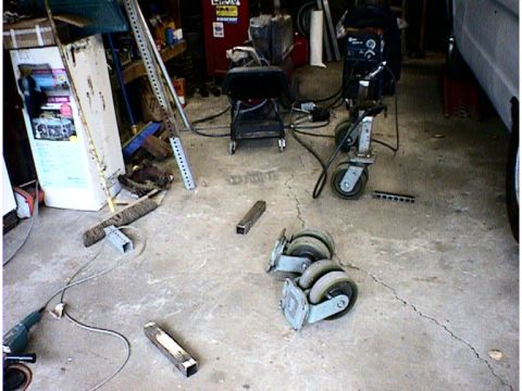 1960 Ford Falcon - Garage scene with various tools and metal components scattered on the concrete floor.