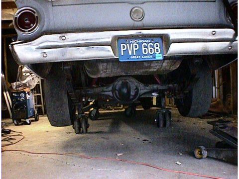 1960 Ford Falcon - The rear end of a 1960 Ford Falcon is shown, lifted on jack stands, with a Michigan license plate.