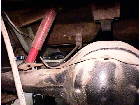 1960 Ford Falcon - Close-up view of a vehicle's rear axle and suspension system, showing a red shock absorber and differential housing.