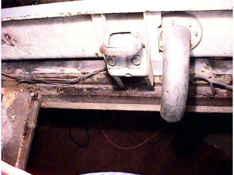 1960 Ford Falcon - Close-up view of a vehicle's undercarriage, revealing exposed wiring and an exhaust pipe.