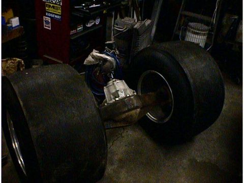 1960 Ford Falcon - A rear axle assembly with large tires and differential is visible in a workshop setting.