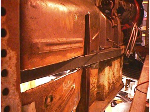 1960 Ford Falcon - Close-up view of a heavily rusted vehicle frame, showing structural components and some wiring details.