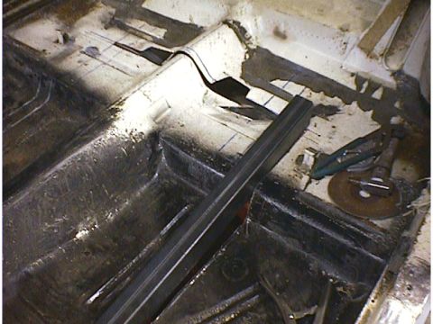 1960 Ford Falcon - The interior floor pan of a vehicle is shown with metal bracing and tools, indicating repair work.