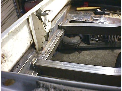 1960 Ford Falcon - Close-up view of a vehicle's frame undergoing repair, showing welding and added structural support.