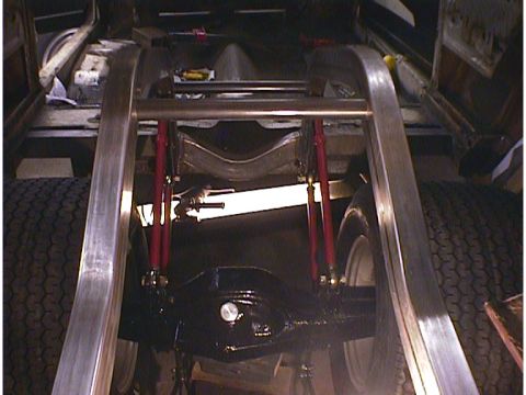1960 Ford Falcon - The underside of a vehicle reveals custom suspension components, including red shock absorbers and a modified frame, suggesting a build or…