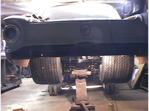 1960 Ford Falcon - Rear axle and tires of a 1960 Ford Falcon are visible while the car is raised on jack stands.