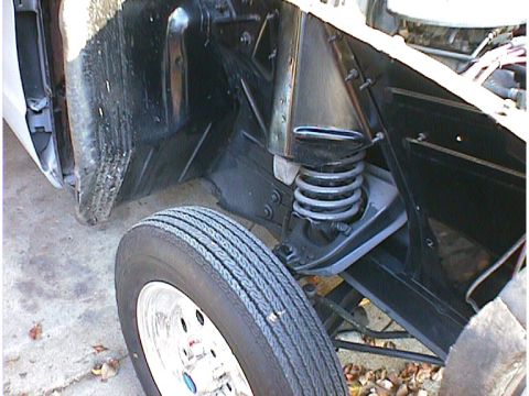 1960 Ford Falcon - A close-up view of the front suspension system and tire of a vehicle.