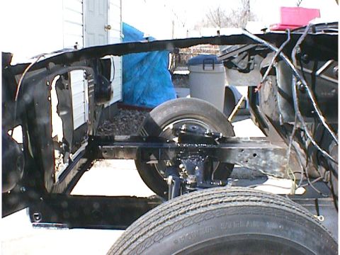 1960 Ford Falcon - The chassis and front wheel assembly of a vehicle undergoing restoration or repair.